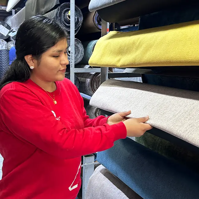 Empleado de Perezoso revisando telas de alta calidad para la fabricación de muebles y camas