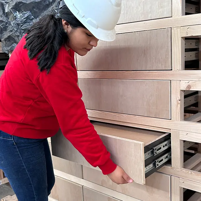 Empleada de Peresozo inspeccionando cajones de muebles durante el proceso de fabricación